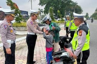 Peduli Keselamatan,  Polda Riau Bagikan Helm ke Pengendara